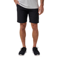 A person in a gray shirt, black Travis Mathew Wanderlust Mens Shorts, and black athletic shoes stands facing forward with one hand in their shorts pocket. The image is shoulder-cropped.