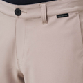 Close-up of Travis Mathew Wanderlust Mens Shorts in beige featuring a black button, belt loop, and a small black waistband label—versatile lightweight shorts ideal for golf or daily wear.