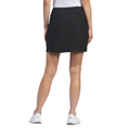 Back view of the black Adidas Ultimate365 Solid Women's Skort, shown with white athletic shoes. The skort has a fitted waistband and falls above the knee.