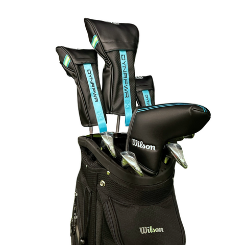 A black Wilson golf bag holds several forgiving clubs with black and blue covers from the Wilson Women's Dynapwr Golf Club Set, displayed against a white background.