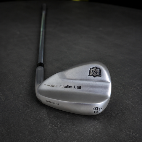 Used Wilson Staff Model 58 degree 10 bounce wedge on dark charcoal Golf 360 workshop workbench